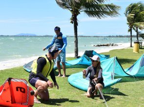 young-smiling-couple-having-fun-on-beach-with-kite-surfing-board-on-summer-vacation-1-1